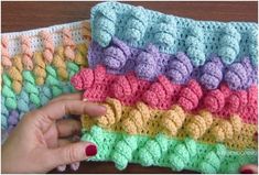 a hand is holding a crocheted dishcloth