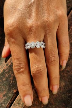 a woman's hand with a diamond ring on top of her left hand,