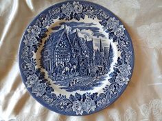 a blue and white plate sitting on top of a bed