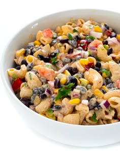 a white bowl filled with pasta salad on top of a table