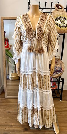 Long kaftan-type dress, made of cotton and with macrame appliqué and fringes. Tassels. Marvelous. Festival Floor-length Maxi Dress With Tassels, Bohemian V-neck Boho Dress For Festivals, White Peasant V-neck Dress, Flowy Boho Dress With Lace Trim For Beach, Bohemian Beach Dresses With Ruffles, Bohemian Ruffled Maxi Dress For Vacation, Festival Boho Dress With Ruffles Maxi Length, V-neck Boho Dress With Tassels For Festival, Maxi Length Ruffled Dresses For Festival