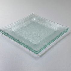 a square glass plate sitting on top of a white table