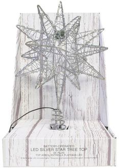 a lighted silver star tree top in a white wooden box with an ad for battery operated leds