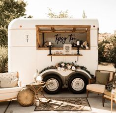 an rv parked on the side of a road with furniture and decor in front of it