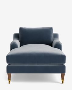 an upholstered blue couch with wooden legs