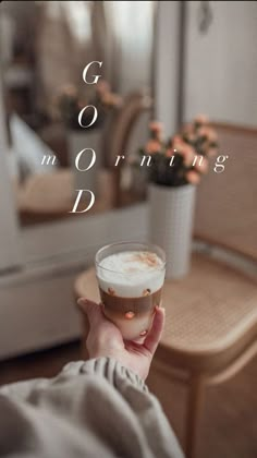 a person holding a drink in their hand with the words good morning written on it