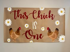 a sign with chickens and daisies on it that says, this chick is one