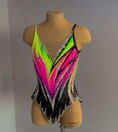 a female mannequin wearing a neon colored leotard with sequins