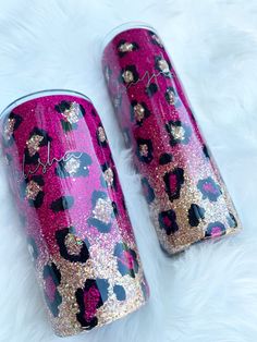 two pink and gold glitter tumbles sitting on top of a white fur covered floor