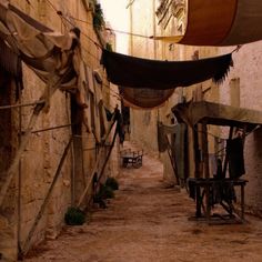 an alley way with clothes hanging on the line and laundry drying in the air next to it