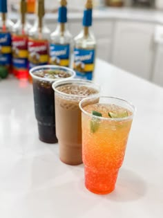 three drinks are lined up on the counter