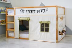 a child's bedroom with a tent bed and bookshelf