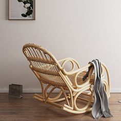 a wooden rocking chair sitting on top of a hard wood floor next to a wall