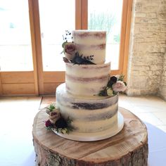 a wedding cake sitting on top of a tree stump