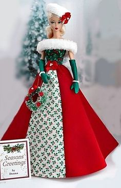 a doll is dressed in red, white and green with a christmas tree behind her