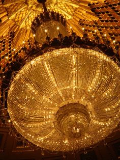 a chandelier hanging from the ceiling in a room with many lights on it