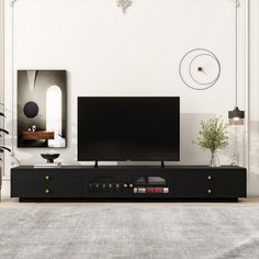 a flat screen tv sitting on top of a black entertainment center in a living room