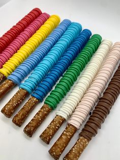 several different colored candy sticks are lined up in a row on a white table top