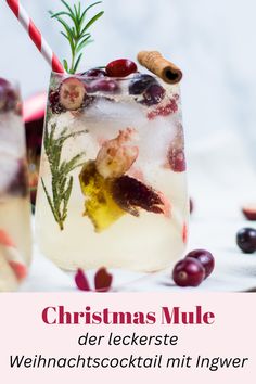 christmas mule with cranberries and rosemary garnish in a glass next to an orange slice