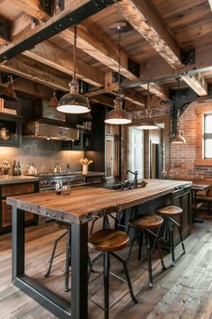 an industrial kitchen with wooden floors and exposed ceilings, along with bar stools that sit at the center of the room