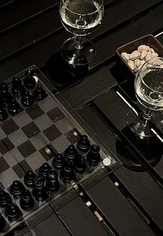 a chess board and some wine glasses on a table