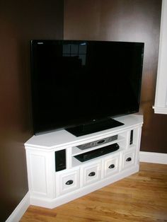 a flat screen tv sitting on top of a white entertainment center in a living room