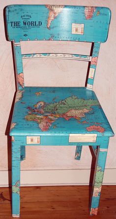 a blue wooden chair with a world map painted on it's back and sides