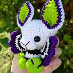 a hand holding a small crocheted stuffed animal