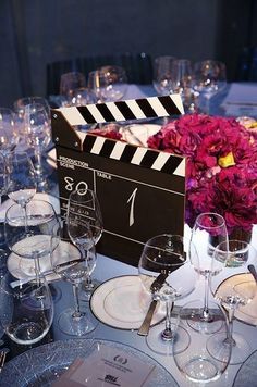 the table is set with wine glasses, plates, and a clapper board on it