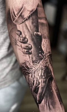 a man's arm with a tattoo on it that has two hands holding each other