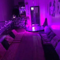 the room is lit up with purple lights and pillows on the floor, along with other furniture