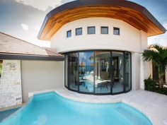 a house with a swimming pool in front of it and an outside dining area on the other side