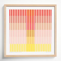 a framed art print with vertical lines in yellow, pink, and orange on the wall