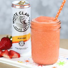 a strawberry smoothie in a mason jar next to a can of white claw