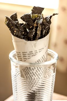 a glass cup filled with some kind of food on top of a wooden table next to a window