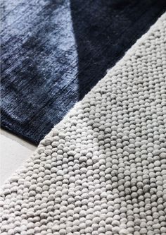 two rugs with different colors and patterns on the floor, one is blue and white