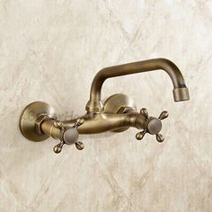 an antique style faucet with two handles on the wall