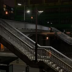 a man riding a skateboard down the side of a metal handrail at night