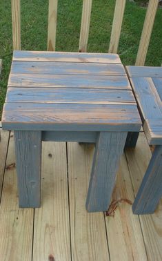 two small wooden benches sitting on top of a wooden deck next to a green field