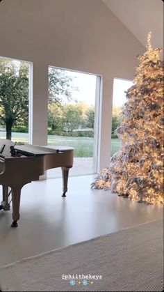 a man sitting at a piano in front of a christmas tree with lights on it