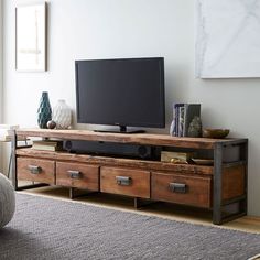 a flat screen tv sitting on top of a wooden entertainment center in a living room