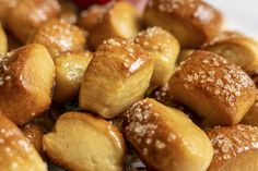 a white plate topped with donuts covered in powdered sugar next to a red bowl