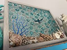 an ocean scene made out of glass and sea shells