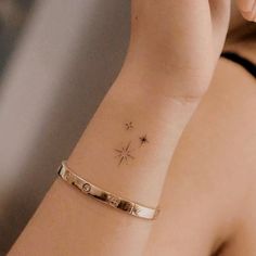 a woman's arm with a small star tattoo on the left side of her wrist