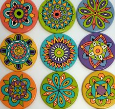 six brightly colored buttons with designs on them