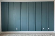 an empty room with blue painted walls and carpet on the floor in front of it