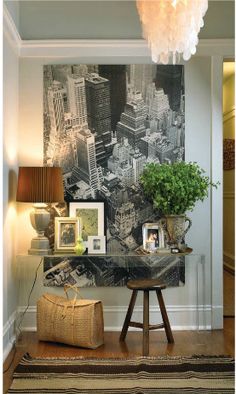 a living room with pictures on the wall and a table in front of it that has a potted plant