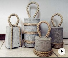 four cement containers with rope wrapped around them