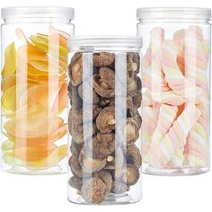 three glass jars filled with different types of candy