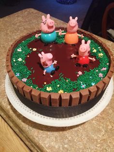 three peppa piggies in the middle of a chocolate cake